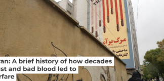 An Iranian walks past an anti-U.S. mural in Tehran on April 5, 2025. Atta Kenare/AFP via Getty Images